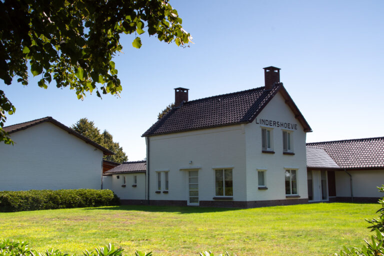 Het witte sanitairgebouw op de minicamping